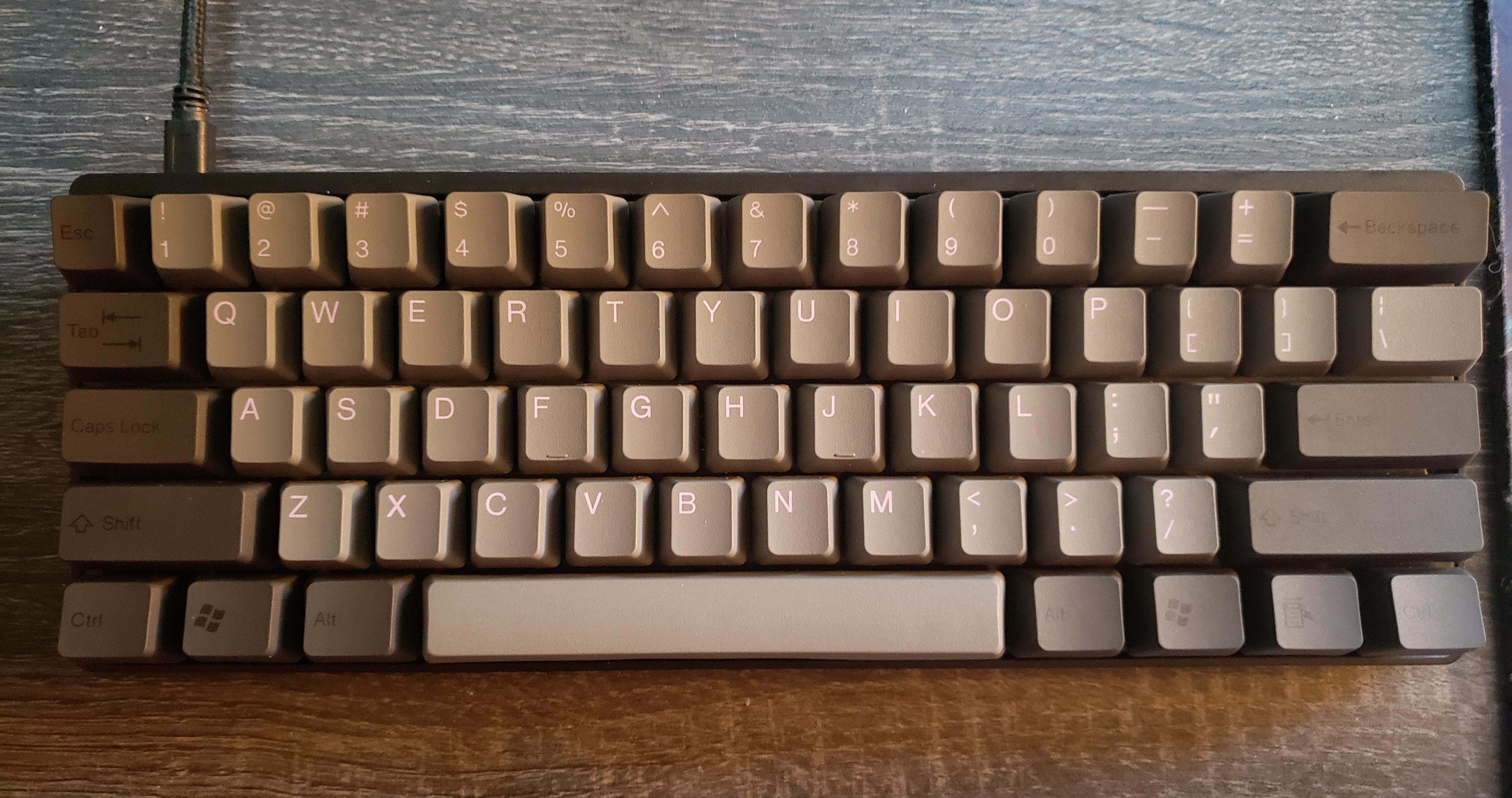 Keyboard on top of a desk showing a brownish pattern, with some keys darker and others lighter